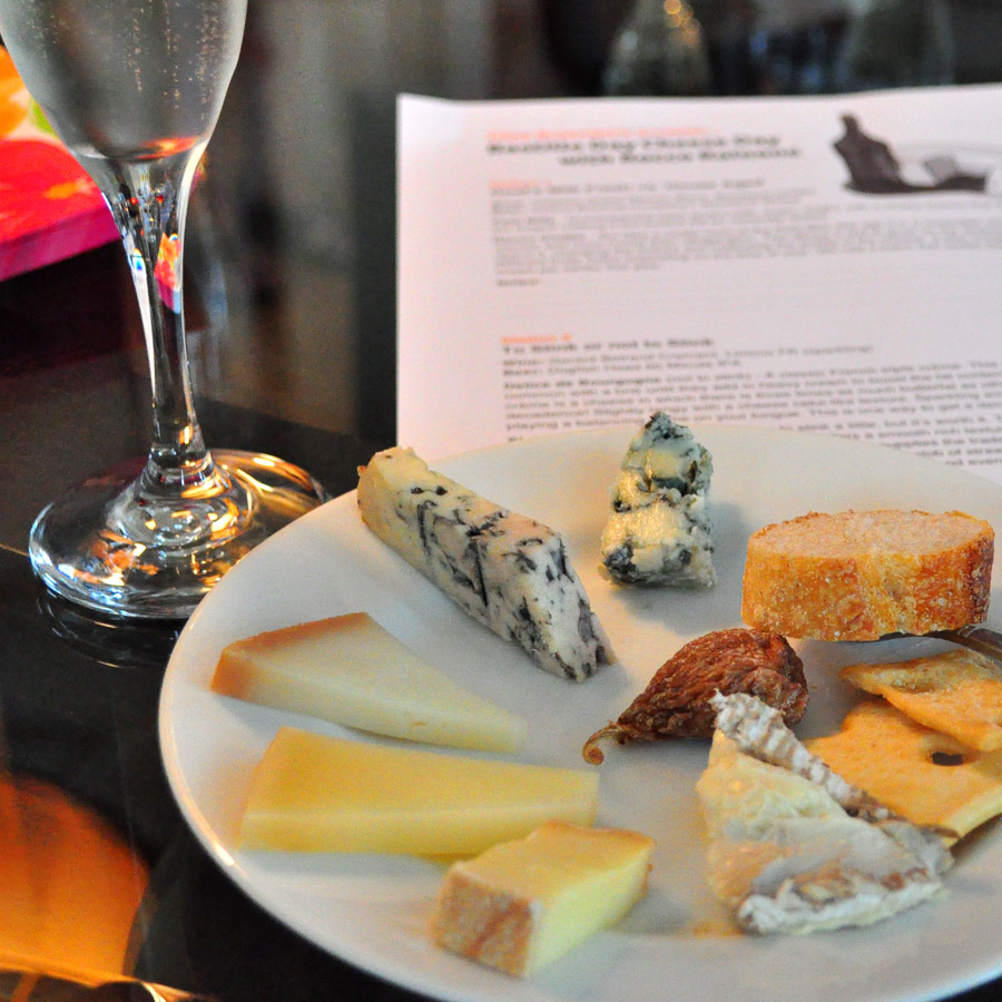 Elegant spread of cheeses on a small plate with champagne glass