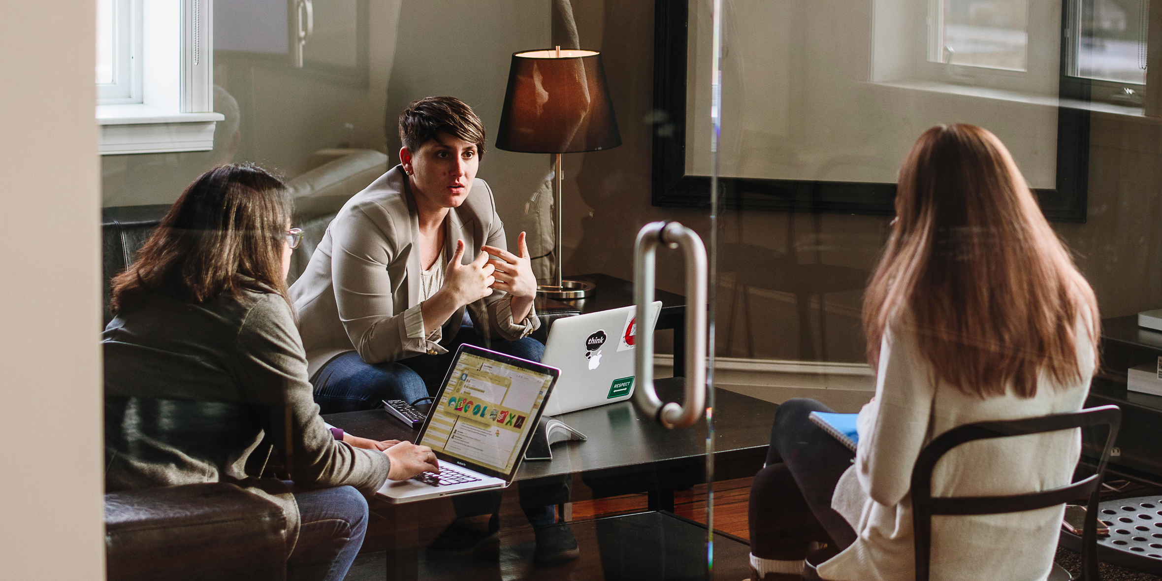 photo of woman talking to two other women