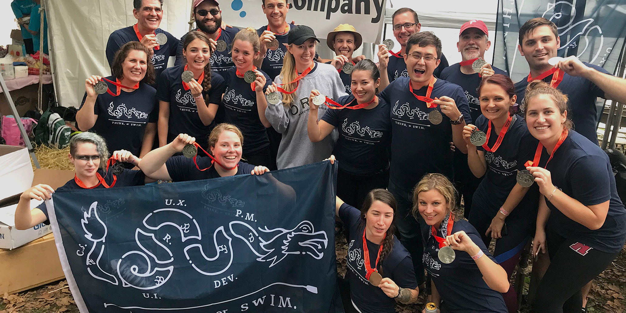 Photo of dragon boat racing team wearing medals holding a flag