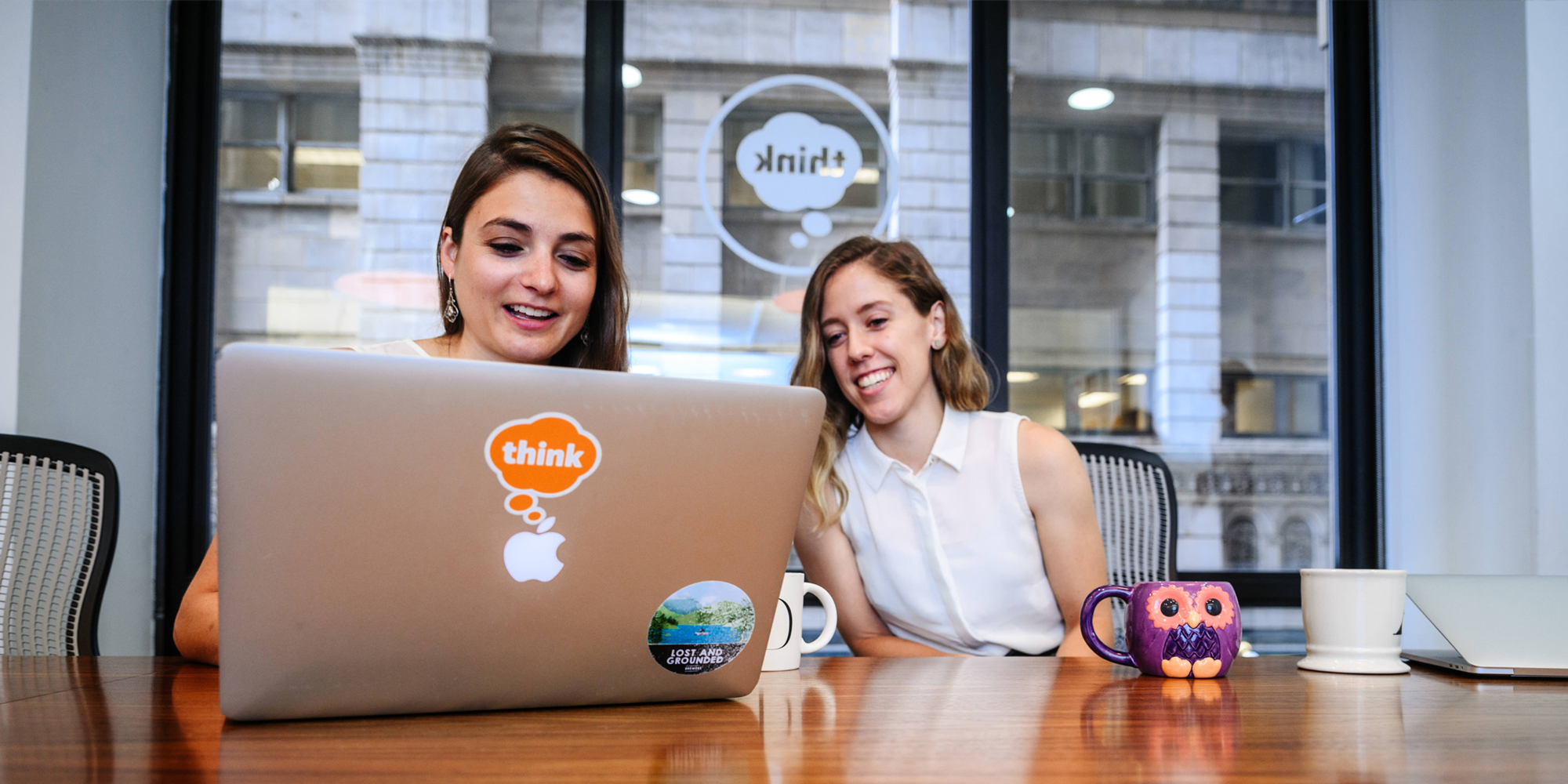 Two UX designers looking at a laptop