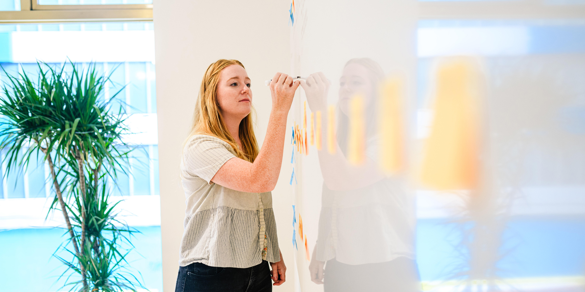 UX designer writing at a whiteboard