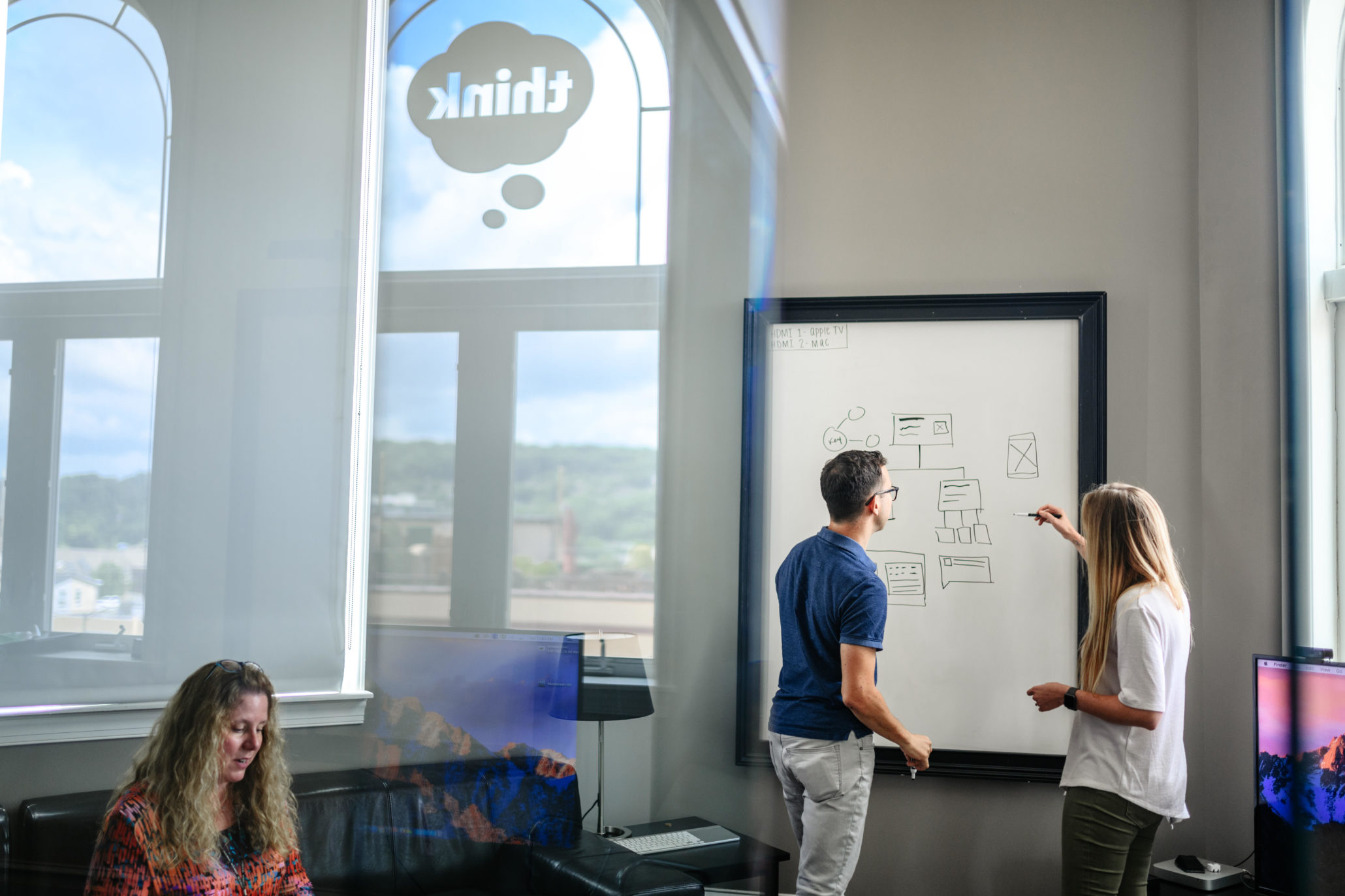 Two designers in front of a whiteboard