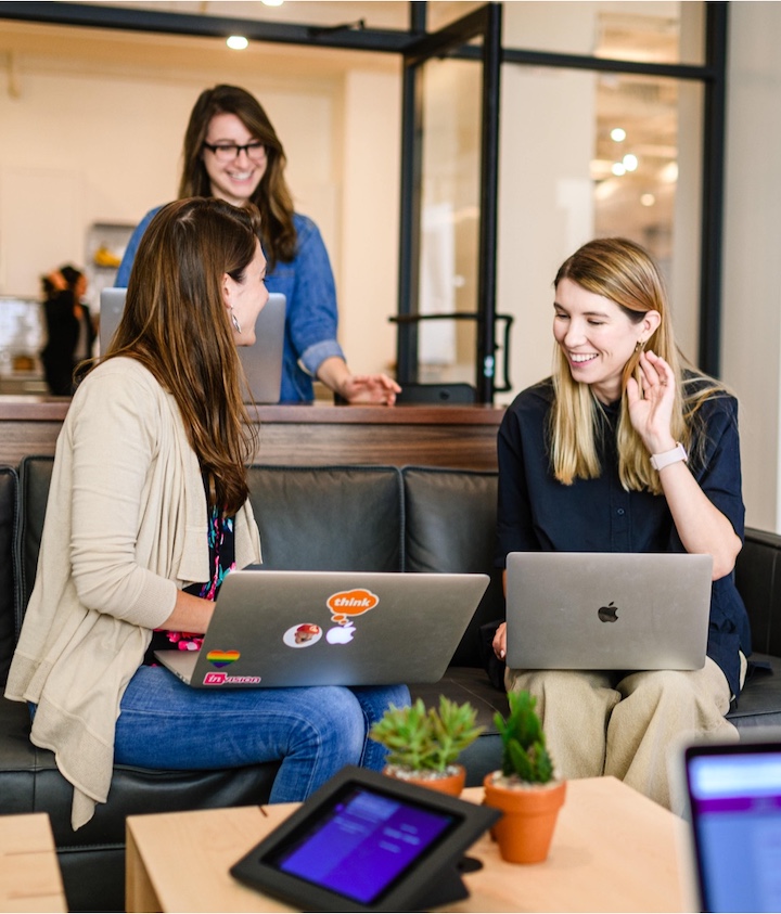 Three people collaborating with laptops in an office
