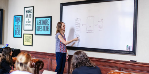 person at a white board leading a creative exercise