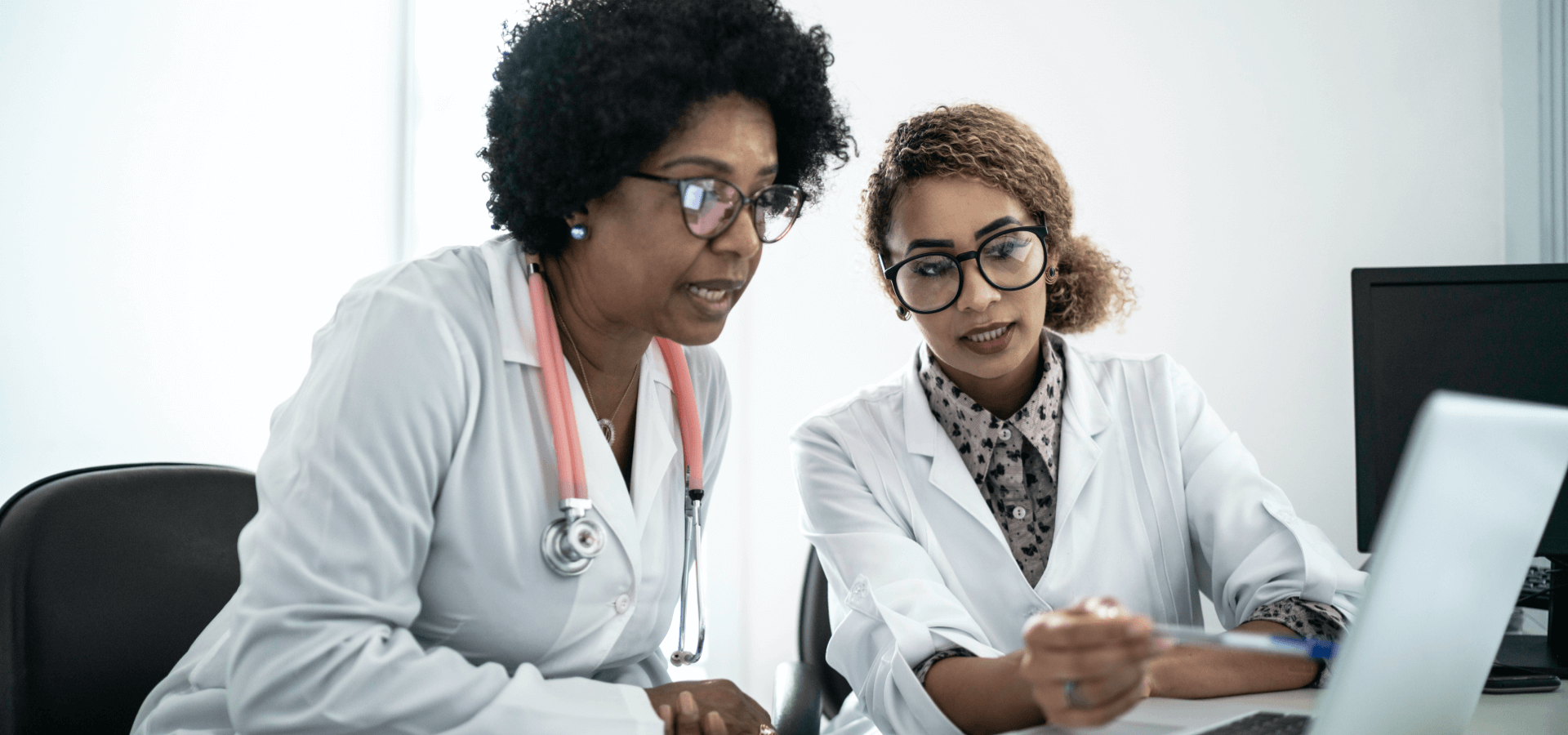 two doctors looking at a laptop