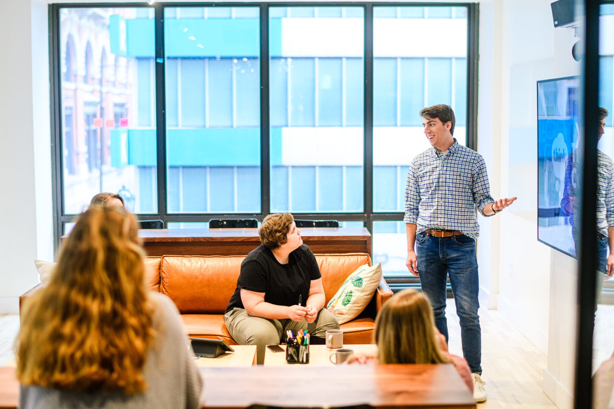 Person presenting to a team of their coworkers