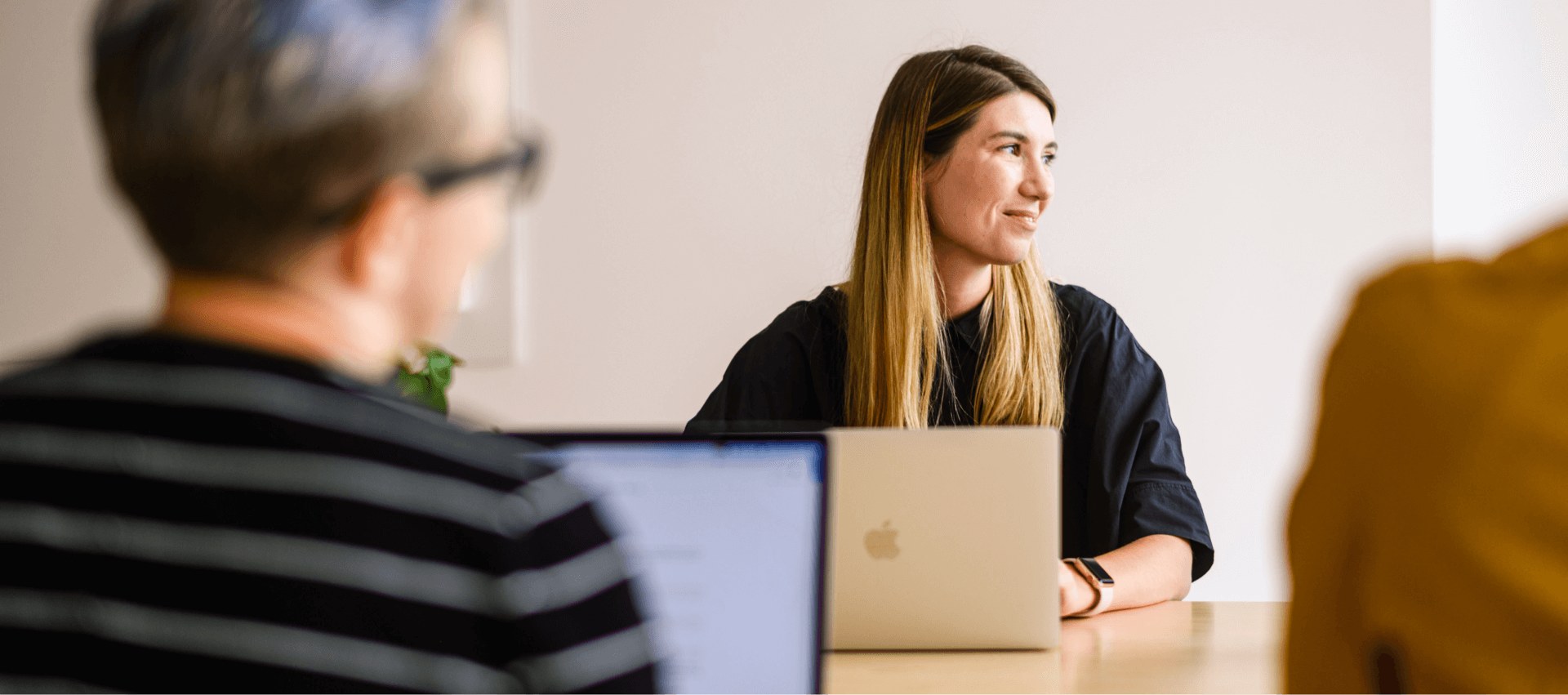 Person sitting with their laptop listening during a meeting