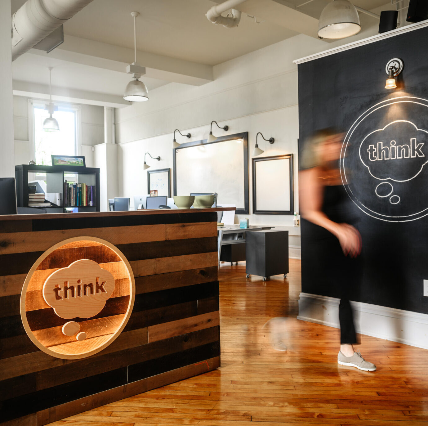 front desk with think logo and blurry person walking by
