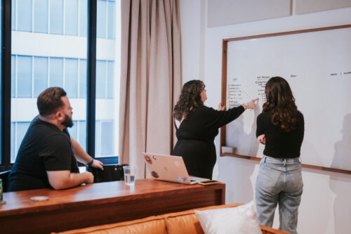 People in a conference room talking and whiteboarding