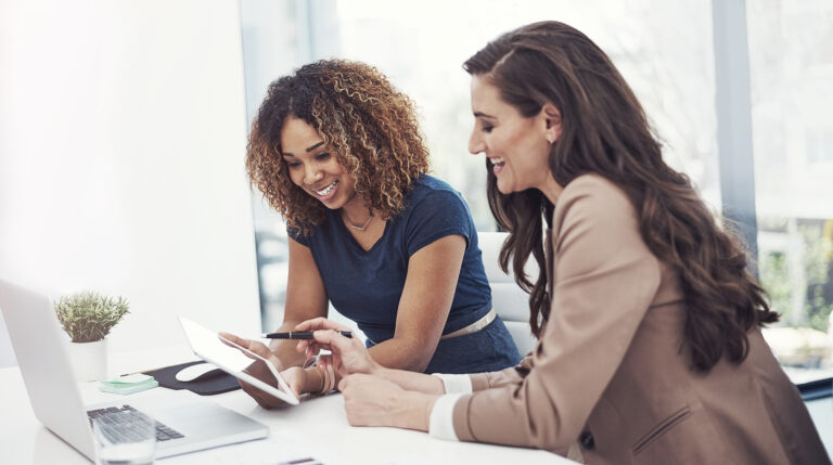 Two people collaborating with a tablet and desktop computer