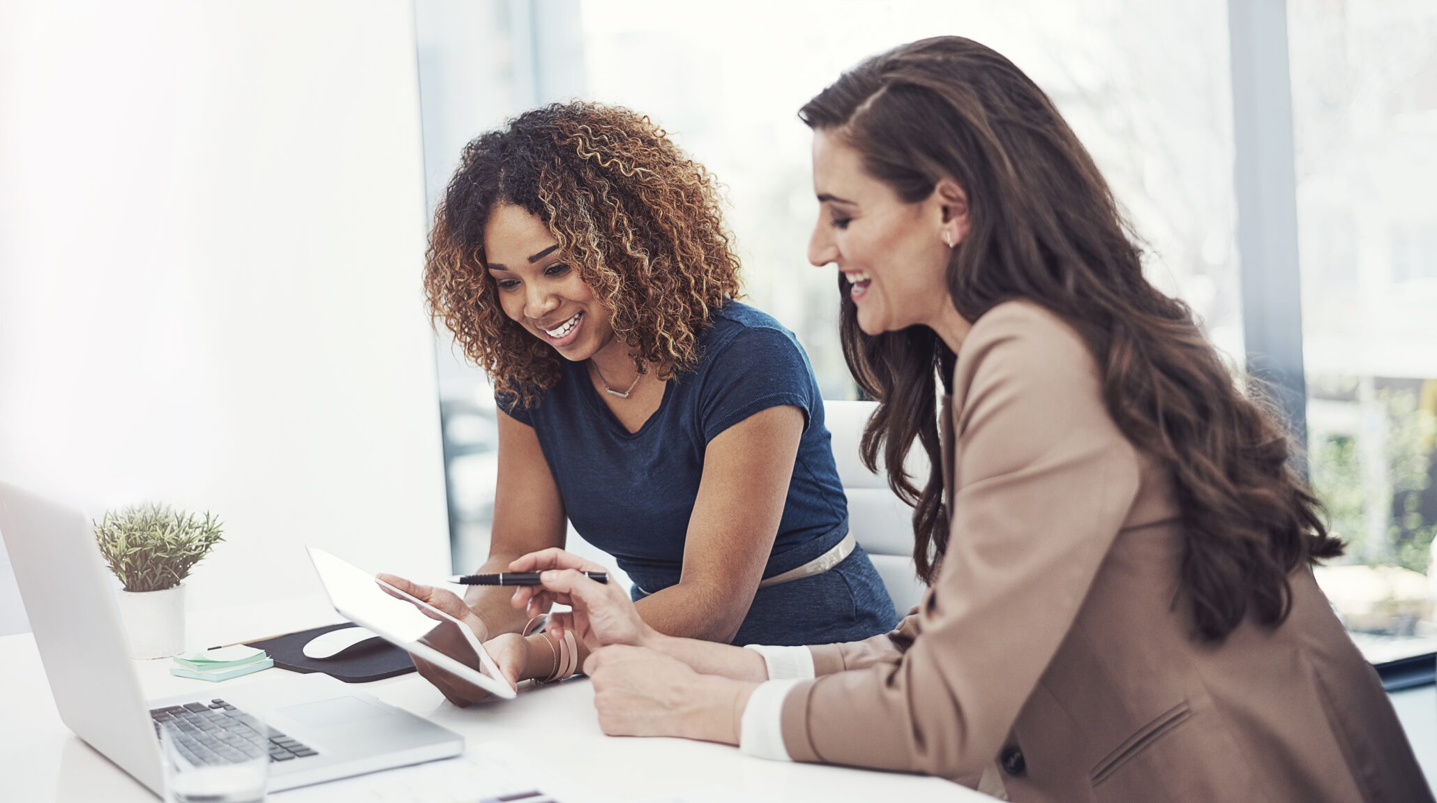 Two people collaborating with a tablet and desktop computer