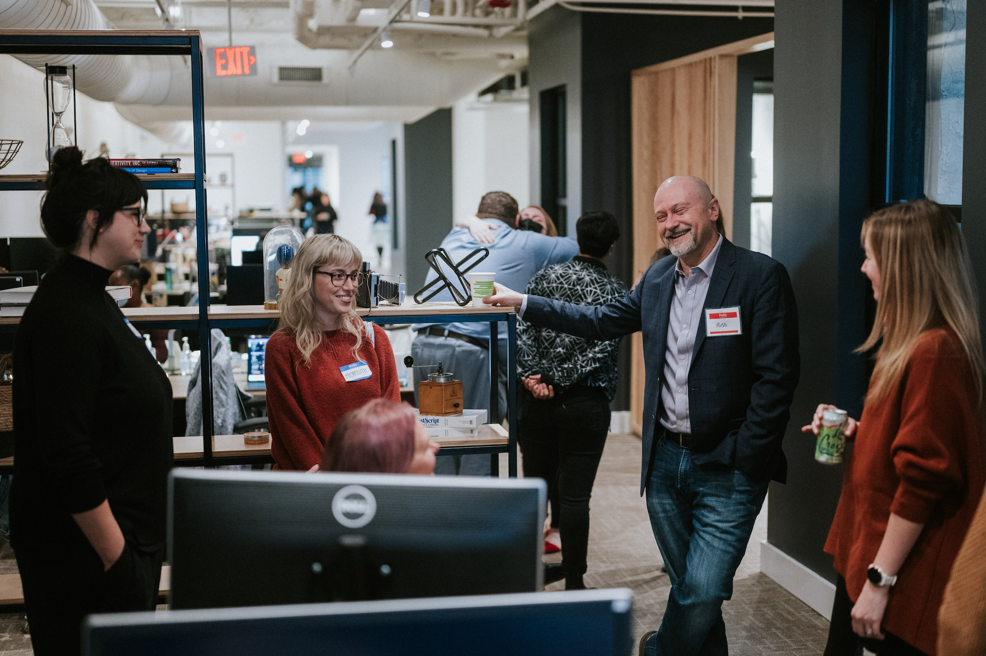 A group of people casually chatting in an office setting