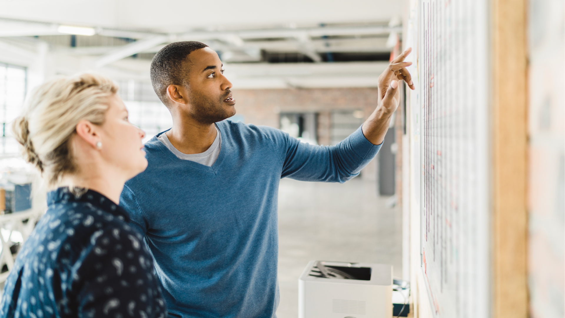 Two people designing a user experience on a white board