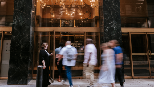 Blurred photo of people walking into a lobby in a city