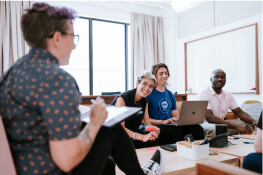 A group of people in a conference room discussing a project