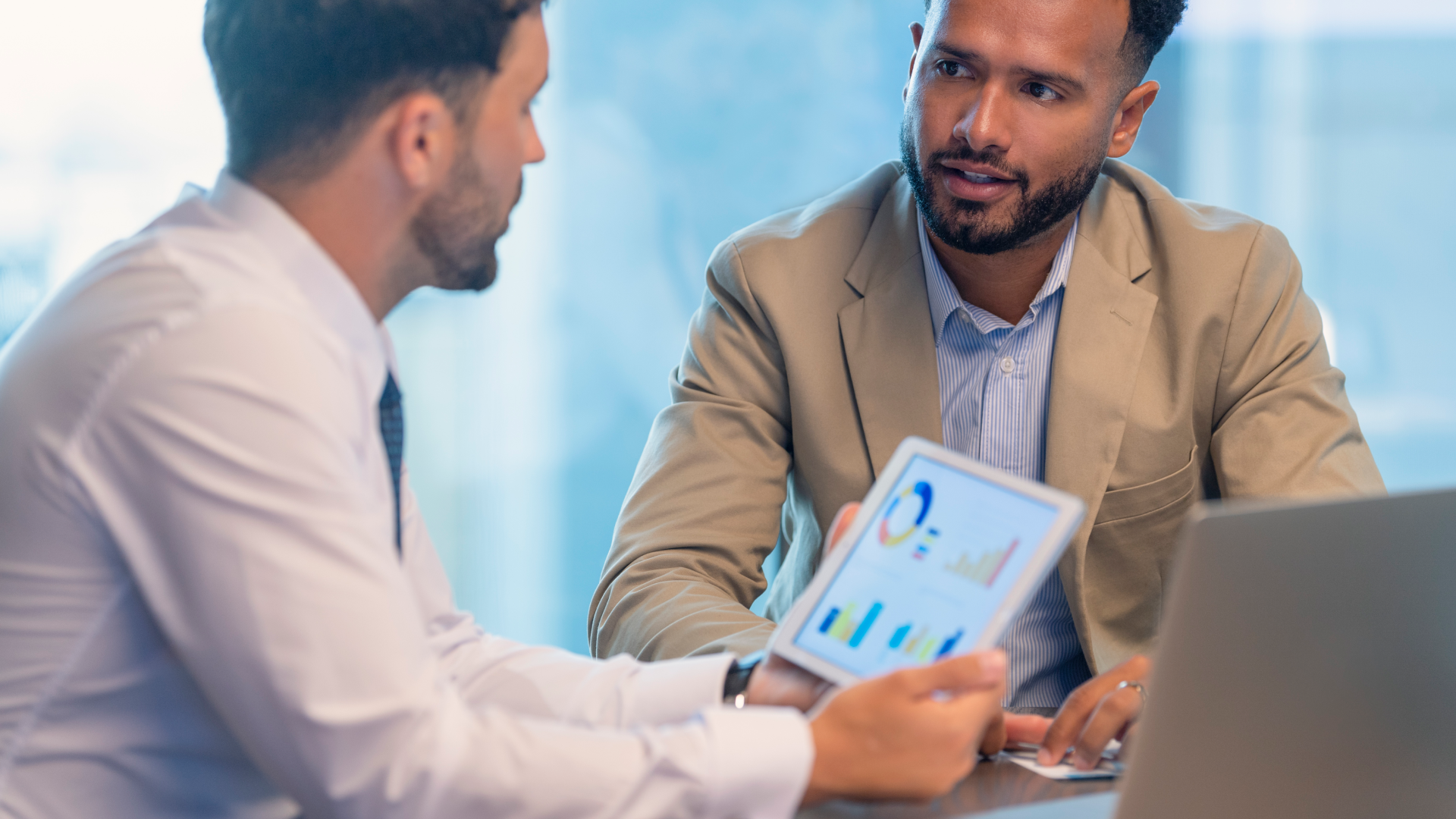 Two people discussing financial services and looking at a tablet