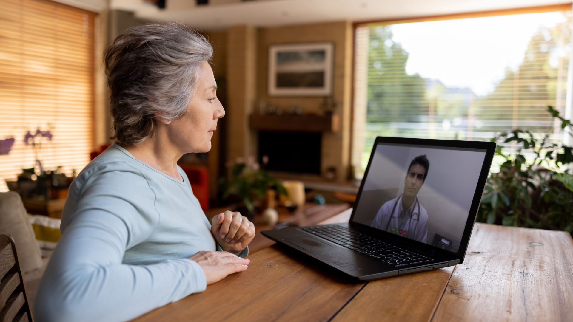 A older person on their laptop in a telehealth call with their healthcare provider