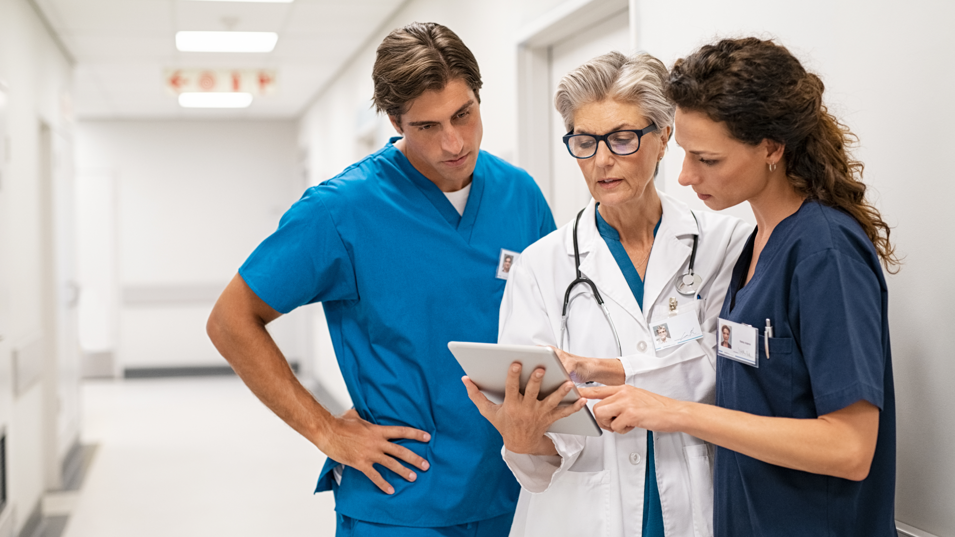 Three pharmaceutical and healthcase professionals looking at a tablet